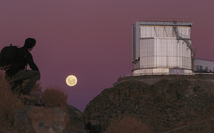 Moonrise behind the NTT telescope, Chile A hiker watches the full moon rise behind the 3.58 metre New Technology Telescope  NTT  at La Silla Observatory, Chile. The NTT was the first telescope in the world to have a computer controlled main mirror  active optics . La Silla is at 2400 metres above sea level on the edge of the Chilean Atacama Desert. It is operated by the European Southern Observatory  ESO .