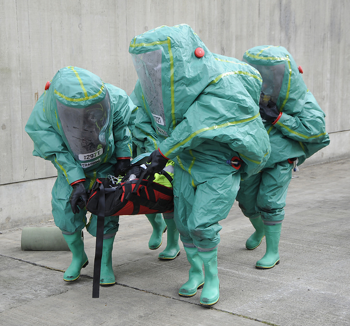 Training exercise for major emergency Training exercise for major emergency. Emergency workers in sealed positive pressure protective suits carrying a casualty on a stretcher. They are taking part in a live training exercise to test the response of the emergency services to a terrorist attack or other major incident. This includes chemical, biological, radiological and nuclear  CBRN  attacks. Photographed in the UK.