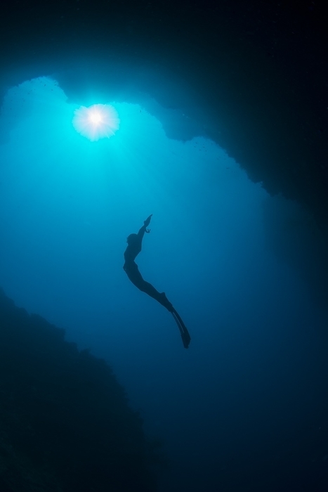 Free diver in mouth of cave A free diver, Ai Futaki, silhouetted in the mouth of a cave. Photographed off Sipadan island, Sabah, Malaysia