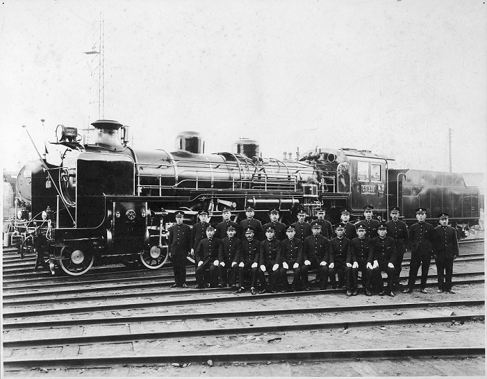 C51 steam locomotive  Date of photograph unknown  Train crew in front of the C51 239 steam locomotive, also known as the  Royal Engine.  It pulled the Imperial Train 104 times.C51 239 was manufactured at the Kisha Seizo Co. during 1927. The engine pulled express trains on the Tokaido main line. After WW2, it did duty on the Uetsu, Shinetsu and Hokuriku lines in Niigata Prefecture.On October 26, 1962, C51 239 was pulled out of service and became the first  Historical Railroad Sub Monument.  It is now exhibited at the Umekoji Steam Locomotive Museum  in Kyoto.