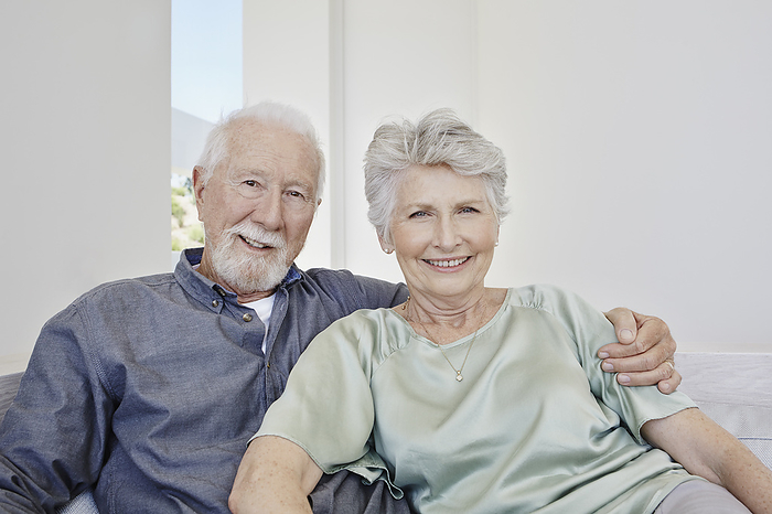 2015 Apollo Lifestyle Familie Portrait of smiling senior couple sitting on a couch in a villa