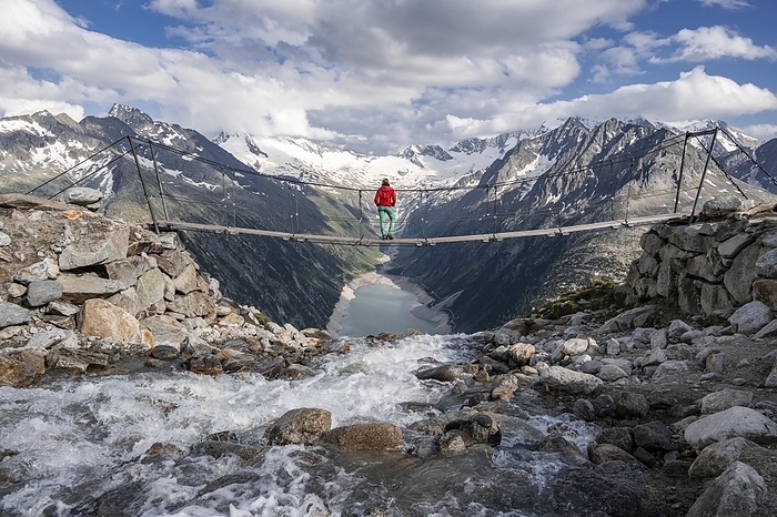 Hiker, woman on suspension bridge at the Olpererhütte, Schlegeis reservoir, Schlegeis reservoir, Zillertal Alps, Schlegeiskees glacier, Zillertal, Tyrol, Austria, Europe, Photo by Moritz Wolf