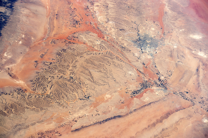 Riyadh region, Saudi Arabia, ISS image Riyadh and the surrounding desert in Saudi Arabia, seen from the International Space Station  ISS . North is towards top right. Riyadh, the capital of Saudi Arabia, is at upper right. It lies on the western edge of the Najd plateau, with the elevation rising to the left of this image which includes numerous rocky ridges and sand dunes, as well as gully eroded hillsides and dry river beds and valleys. The river bed running through the city itself is called Wadi Hanifa. Photographed by an Expedition 42 astronaut on 9 November 2014.