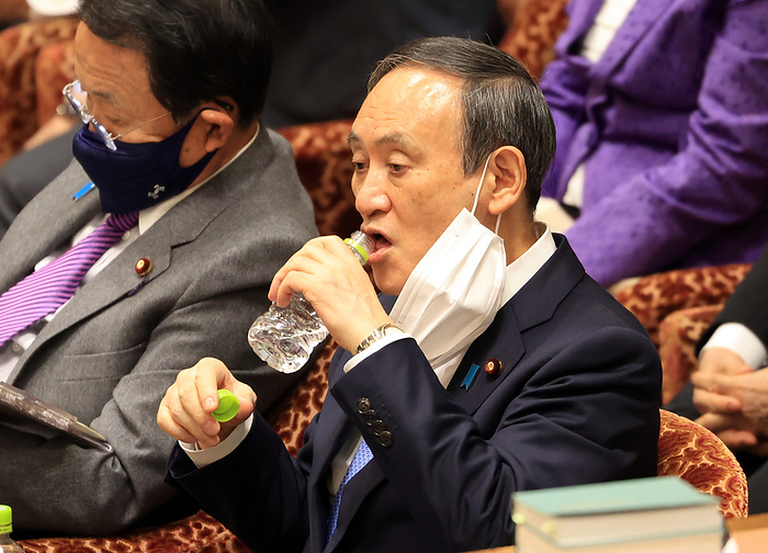 Japanese Prime Minister Yoshihide Suga attends Lower House s budget committee session February 8, 2021, Tokyo, Japan   Japanese Prime Minister Yoshihide Suga drinks water as he listens to a question at Lower House s budget committee session at the National Diet in Tokyo on Monday, February 8, 2021. Suga cabinet s approval rating dived under 40 percent, accoding to a telephone poll.         Photo by Yoshio Tsunoda AFLO 