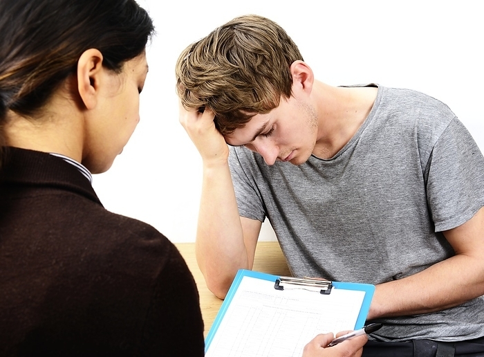 Depression consultation Depressed young man in consultation with a doctor or psychologist.