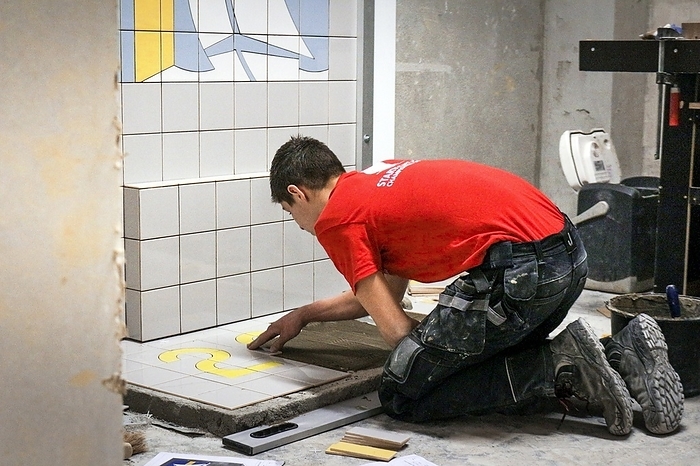 Tile laying demonstration Tile laying demonstration. Craftsman demonstrating his skills at laying tiles at an industrial trade show. This is Startech s Days 2016, a trade show and competition organised by Bruxelles Formation and held in Brussels, Belgium. The show includes championships for manual and technical trades. Photographed on 15 March 2016.