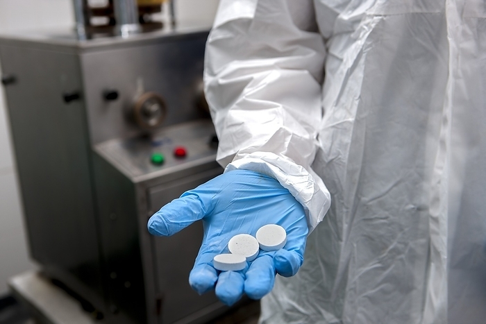 Water purification tablets production Water purification tablets production. Tablets of sodium dichloroisocyanurate  NaDCC , or effervescent chlorine, being held in the gloved hand of a factory worker. These tablets produce chlorine when added to water, which has the effect of purifying the water and making it safe to drink. The tablets are highly effective in killing the microbes in contaminated water that cause dysentery, diarrhoea, cholera and other water borne diseases. The tablets can be used against bacteria, bacterial spores, cysts, algae, fungi, protozoa and viruses. These tablets are being manufactured by the Scotmas company in Scotland. Photographed in 2016.