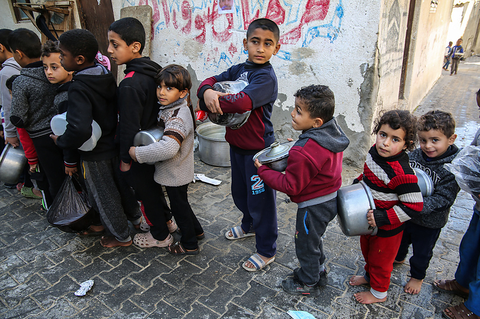 Food aid to needy families in Gaza Palestinian children carry pots as they wait to receive a meal prepared with ingredients obtained from donors wishing to help needy families, in an impoverished neighbourhood in Gaza City, on February 1, 2021.