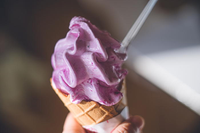 Hands holding dragon fruit soft serve ice cream. Delicious tropical fruit ice cream with high nutritional value.