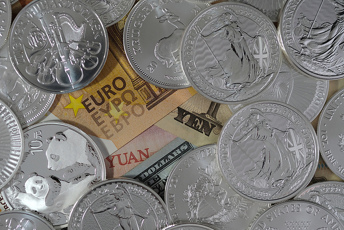 In this photo illustration 1oz silver bullion coins are arranged atop banknotes of euro, Japanese yen, Chinese yuan, and a US dollar bill on February 20, 2021 in Katwijk, Netherlands.  (Photo by Yuriko Nakao/AFLO)

