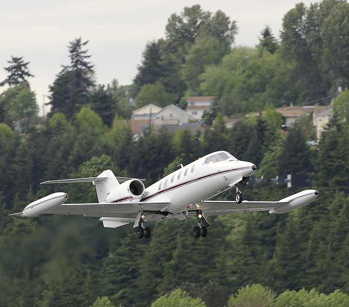 Learjet taking off Executive Flight Bombardier Learjet 35A taking off with trees and houses behind.