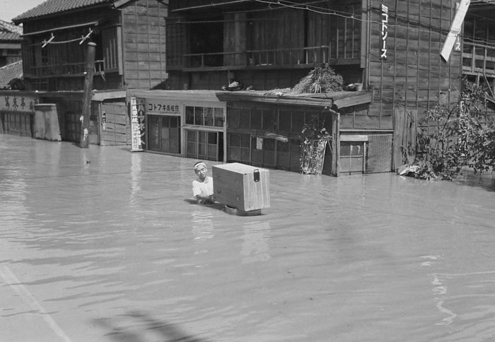 Residents carrying chests of drawers in a washbasin in Tokyo in September 1947. Photographed by a member of the photography club in September 1947 *Sun Photo Newspaper