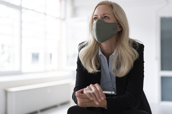 businesswoman Businesswoman wearing face mask looking away while standing in home office
