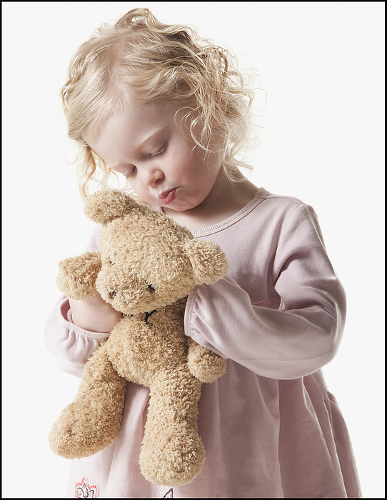 Tired young girl holding teddy bear