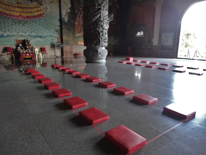 Zazen futons lined up in the empty main hall of the temple