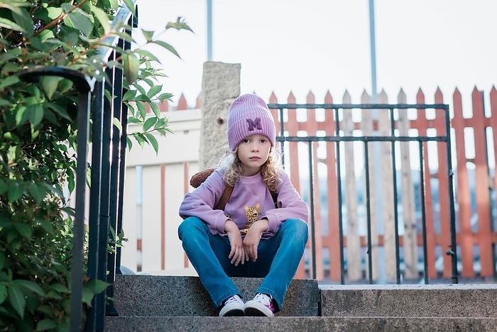 girl young girl sitting on a step looking thoughtful waiting for school