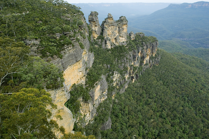 Three Sisters rock formation, Australia Three Sisters rock formation at the Blue Mountains National Park, in New South Wales, Australia. Photographed from Echo Point overlooking the Gedumbah Valley. The Three Sisters are famous rock formations formed by water seeping into small cracks in the rock. The cracks grow larger over time to form large indentations. The Blue Mountains are made up of sandstone, which is easily eroded away by wind and rain.