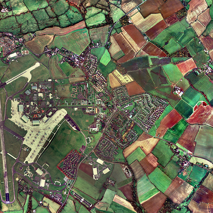 Lyneham, Wiltshire, UK, aerial photograph Lyneham, Wiltshire, UK, aerial photograph. This village  centre  has a population of about 4000 people  as of 2001 . Agricultural fields surround the village. At centre left are the buildings and runways of RAF Lyneham. This Royal Air Force base opened in 1940. In recent years, Hercules aircraft have flown from here on missions across the world.