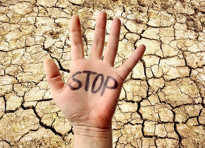Environmental protest Environmental protest. Conceptual image showing a hand with  STOP  written on it, and a background of dried and cracked mud. This represents people protesting on environmental issues such as drought and climate change.