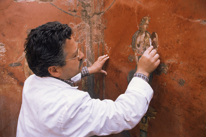 Archaeologist cleaning a fresco, Pompeii Murecine hotel fresco, Pompeii, being cleaned by an archaeologist. Murecine was a large hotel located just outside the town of Pompeii, Italy. Pompeii was a thriving town of some 20,000 inhabitants before it was destroyed by the eruption of the nearby volcano Vesuvius on 26th August 79 AD. The town was buried under a deep layer of ash, and lay undiscovered until 1599, although serious excavations did not start for another 150 years. The town s demise was rapid. Most of the inhabitants were killed, and their remains preserved in the ash. Buildings, statues, works of art and everyday items were also preserved, revealing much about life at the time. Pompeii is now a UNESCO World Heritage Site.