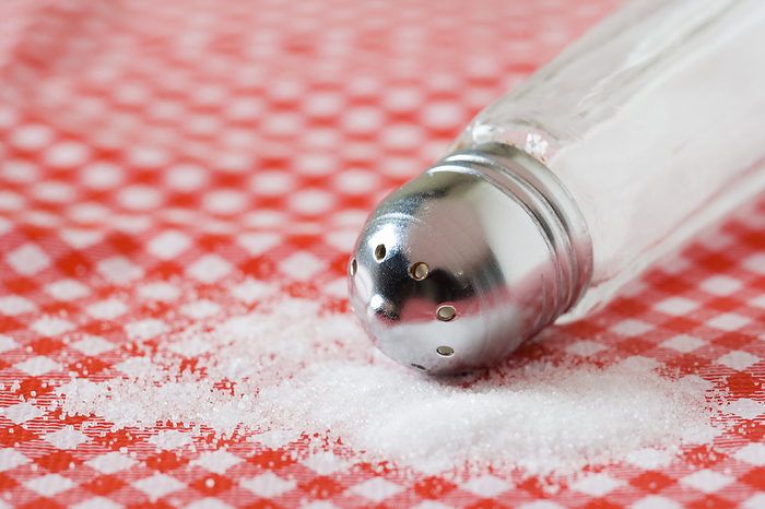 Salt Salt spilling from a salt shaker onto a table.