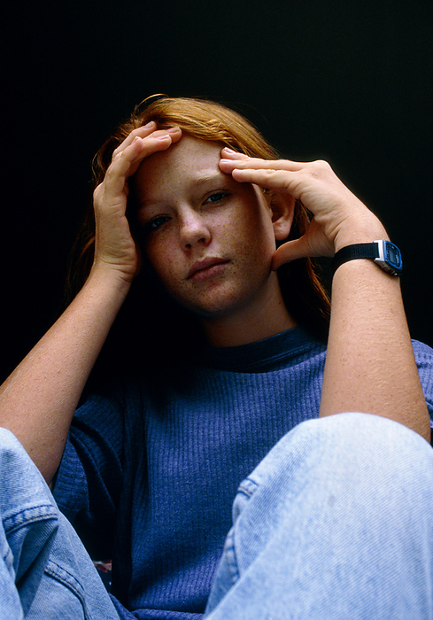 Depressed teenage girl holding her head Depression or sadness. Teenage girl sits holding her head in a sombre, lonely and depressed mood. Mild depression such as symptoms of sadness or despair is experienced by most people at some point in life. It is most common in teenage years with more women seeking help for depression than men. Treatment for severe cases of depression may include psychotherapy and anti  depressant drugs, and is usually successful.