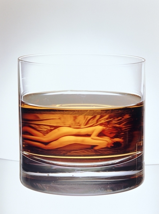 Glass of alcohol with image of naked couple on bed Alcohol addiction. Glass of alcohol, with an abstract image of a naked couple reflected in the liquid. The couple appear to be in conflict and the woman is passifying the man. Marital or emotional conflict may lead to heavy drinking. Alcohol is an addictive substance which acts as a depressant on the nervous system, and so reduces anxiety, tension and inhibitions. Dependency on alcohol  alcoholism  is an illness which leads to withdrawal symptoms when drinking is suddenly stopped. Long term and excessive alcohol consumption may cause irreversible damage to the heart, liver, brain and nervous system.