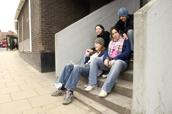 Underage drinking MODEL RELEASED. Underage drinking. Group of teenagers drinking on steps.