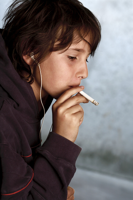 Underage smoking MODEL RELEASED. Underage smoking. Nine year old boy smoking a cigarette.