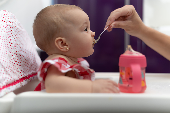 baby eating porridge, sela gives her mother