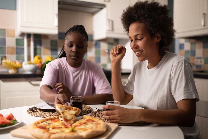 Multiracial women eating pizza together Multiracial women eating pizza together