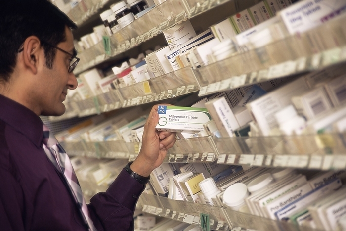 Hospital pharmacist Hospital pharmacist selecting a drug. He has selected metroprolol tartrate tablets that are used to treat high blood pressure and heart conditions  metroprolol is a beta blocker drug . This hospital is part of England s National Health Service  NHS . Photographed at St Richard s Hospital, Chichester, West Sussex, England.