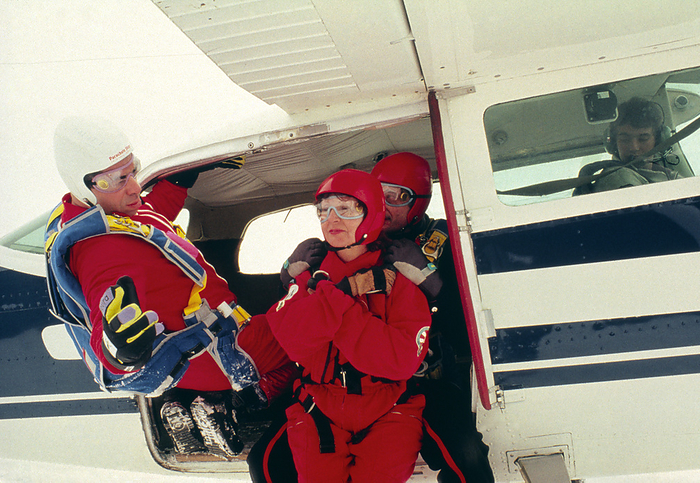 Hypnotherapist patients in parachute jump Hypnotherapy and stress alleviation. A parachute instructor briefs a patient who has just received hypnotherapy treatment for stress. Under hypnosis, the patient and therapist talked through all aspects of the parachute jump, confronting the patient s fears. After coming out of hypnosis, the patient is able to deal with the stress and anxiety of the jump. This is part of a research programme into self help techniques for people suffering from stress. The parachute jump is simply a controllable stress input, a common analogue to the different stresses felt by different patients.