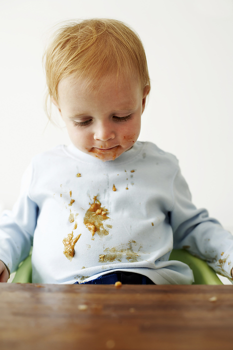 Messy child MODEL RELEASED. Messy child eating his food. He is eighteen months old.