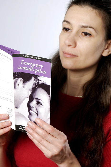 Emergency contraception guide MODEL RELEASED. Contraception information. Woman reading leaflet on emergency contraception.