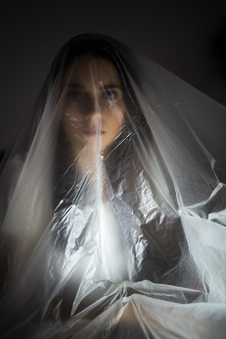 female Young woman covered with plastic at home during pandemic, Photo by Giorgio Fochesato
