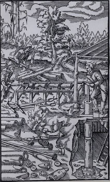 Mine drainage.  Basle, 1556 . Woodcut. Mine drainage. Man in centre left of picture is boring lengths of wood with borers and augers to form pipes. Man on centre right is working the piston rod of a suction pump to raise water from a mine. In the left foreground are lengths of pipe to be joined, and various internal pump parts. From  De re metallica , by Agricola, pseudonym of Georg Bauer  Basle, 1556 . Woodcut.