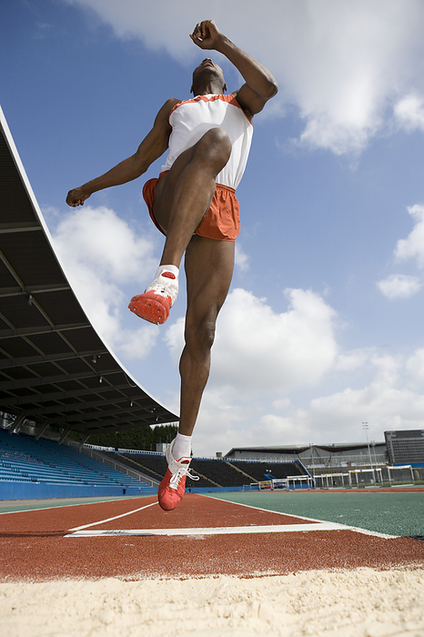 Athlete performing a long jump MODEL RELEASED. Athlete performing a long jump. In athletics the long jump is a track and field event in which the athletes attempt to land as far from the take off point as possible after sprinting down the runway.