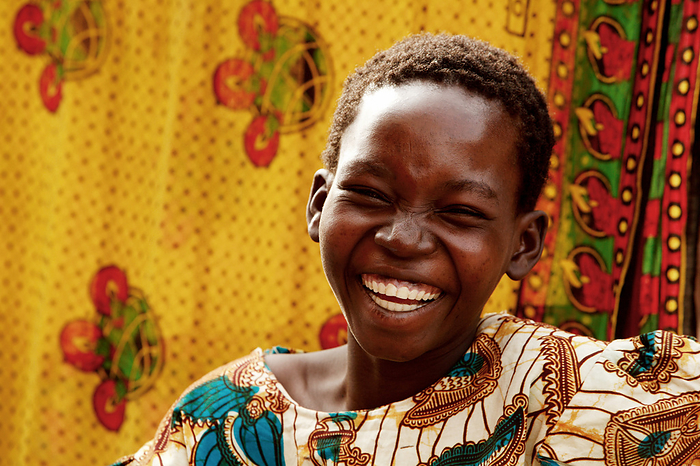 Ugandan child laughing Ugandan child laughing. Traditionally printed cloths, called a khanga  also known as a kitenge , are seen in the background. Photographed in a rural village in Gulu, Uganda.