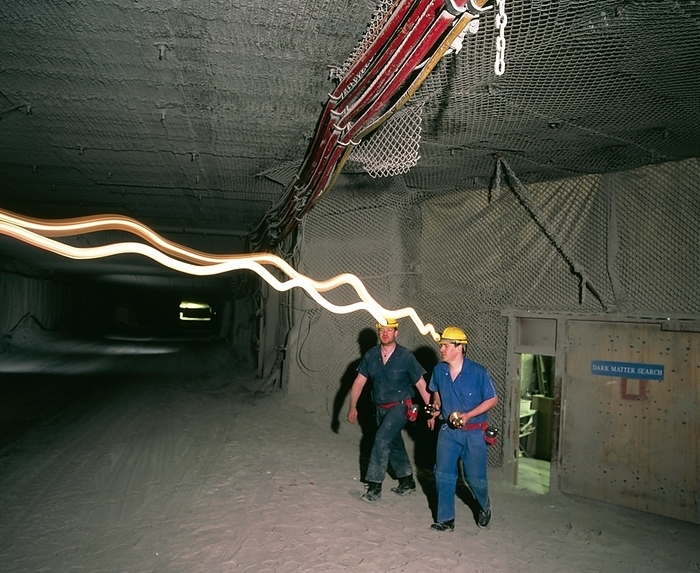 Boulby Mine, site of a WIMP detector WIMP detector site. Time exposure image of workers at the UK Dark Matter Collaboration  UKDMC  proj  ect, Boulby Mine, Britain, which looks for Weakly  Interacting Massive Particles  WIMPs . About 90  of the universe s mass may be made of invisible dark matter such as WIMPs, the rest being made of visible matter such as stars. The UKDMC is the first site to be funded solely to search for WIMPS. Its detectors are 1100 metres underground in Europe s deepest mine so that the overlying rock blocks cosmic rays. WIMPs are to be detected by observing the recoil energies of normal nuclei after a collision with a WIMP, a rare event due to the WIMPs  weak interaction with other matter.