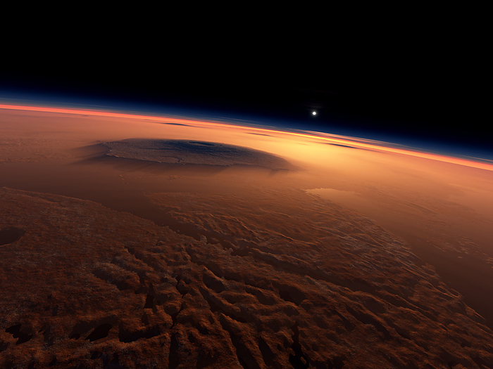 Sunrise over water on Mars Water on Mars. Computer artwork looking east over Olympus Mons  large shadow, upper left  at dawn on Mars 3.5 billion years ago. Water  centre right  shines in the sunlight. Mars is now a desert world, but erosion features seen on Mars today suggest that water once flowed there. The water was lost due to the thin Martian atmosphere and weak gravity. Olympus Mons volcano is the largest mountain in the solar system. It is 24 kilometres high and over 600 kilometres wide. The background shadows  left to right  are Ascraeus Mons, Pavonis Mons and Arsia Mons. This topography was drawn with Terragen software, using data from the laser altimeter on the Mars Global Surveyor probe.