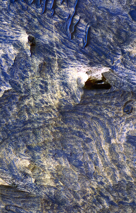 Fluvial erosion on Mars Fluvial erosion on Mars. Colour enhanced satellite image of the Candor Chasma region of the Valles Marineris canyon. It is thought that this canyon initially formed as the result of tectonic fracturing of the upper crust of Mars. The fractures, or joints, are visible as approximately vertical thin blue lines bordered by yellow areas  upper left to lower left . The yellow areas are halos, interpreted as areas of rock that have been chemically altered by fluid flowing through the joints. This image was obtained by the High Resolution Imaging Science Experiment  HiRise  camera on board the Mars Reconnaissance Orbiter, September 30th, 2006.