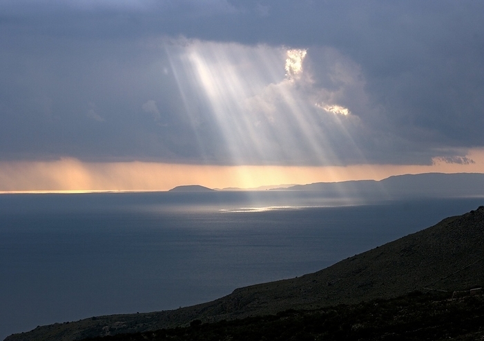 Shafts of sunlight Shafts of sunlight falling through storm clouds over the sea. Photographed at sunset on the Mani peninsula, Greece, in April. This view is looking west towards Koroni.