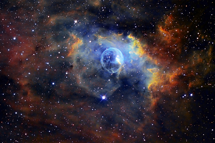 Bubble nebula  NGC 7635  Bubble nebula  NGC 7635 , optical image. This nebula is named for the circular shell of gas  blue  at centre. This hollow shell has been excavated out of the surrounding nebula by the powerful stellar wind of a massive star within it. The entire nebula glows as the gases it contains are ionised by radiation from hot young stars that have formed within it. Different colours have been assigned to different ionised gases here  sulphur is red, hydrogen is green and oxygen is blue. The nebula lies some 11,000 light years from Earth in the constellation Cassiopeia.