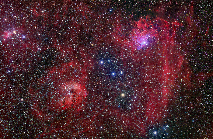 Emission nebulae, optical image Emission nebulae, optical image. Emission nebulae are clouds of gas and dust that glow as the hydrogen gas they contain is ionised by radiation from the hot stars embedded in them. The Flaming Star nebula  IC 405  is seen at upper right with its neighbour the Tadpole nebula  IC 410  at lower left. IC 405 is illuminated by the bright star AE Aurigae, while IC 410 is lit by a cluster of young stars  NGC 1893  that formed from the coalescence of gas from the nebula, leaving dark holes in its structure. The flaming star nebula lies about 1600 light years from Earth, in the constellation Auriga.