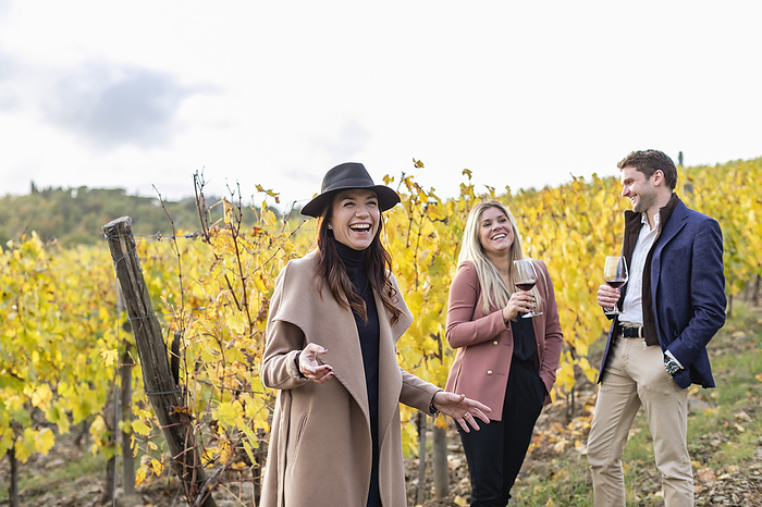 businesswoman Smiling businesswoman showing vineyard to clients during autumn