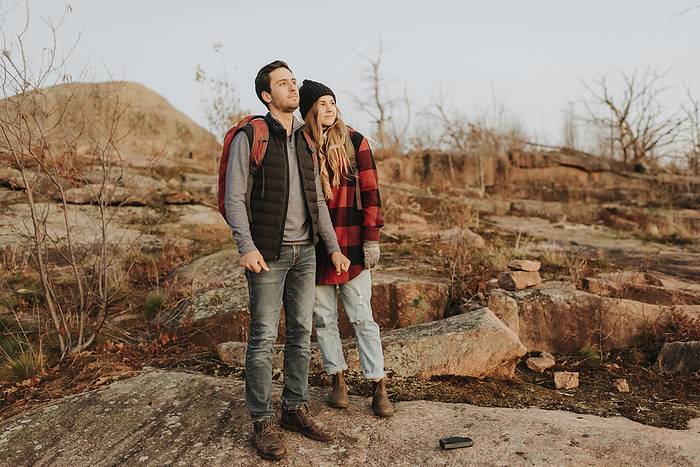A couple s hike in the fall. Location: Ontario, Canada Young couple standing together and admiring surrounding landscape during autumn hike