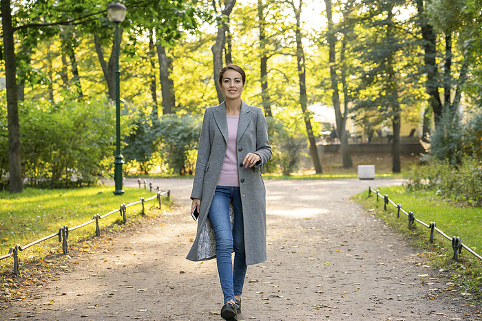 female Happy businesswoman during autumn walking in park