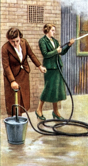Air Raid Precautions': Set of 50 cards issued by WD & H0 Wills, Britain 1938, in preparation for the anticipated coming of World War II. Women fighting fire with stirrup hand pump.