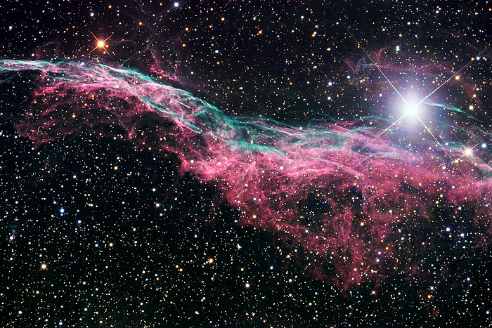 Veil nebula supernova remnant  NGC 6960  Veil nebula supernova remnant  NGC 6960 , optical image. This wisp of glowing gas is part of a much larger spherical shell called the Cygnus Loop. The shell comprises stellar material ejected in a supernova, the explosive death of a massive star. The supernova forming this shell is thought to have occurred between 5 8000 years ago. The gas was cast off into space at high speeds, and when it impacted the interstellar medium it compressed and heated it, forming a glowing plasma. The bright star at upper right is 52 Cygni, which is unrelated to the supernova. The distance to the nebula is a matter of debate, with estimates ranging from 1400 to 2600 light years. It lies in the constellation Cygnus.